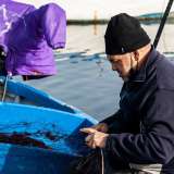 ...uno dei quali ospita un altro anziano lavoratore del mare intento a tagliare una rete
